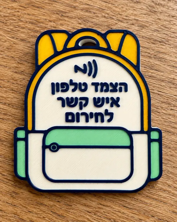 תג NFC בצורת ילקוט בהדפסת תלת־ממד, עם הכיתוב «הצמד טלפון — איש קשר לחירום»